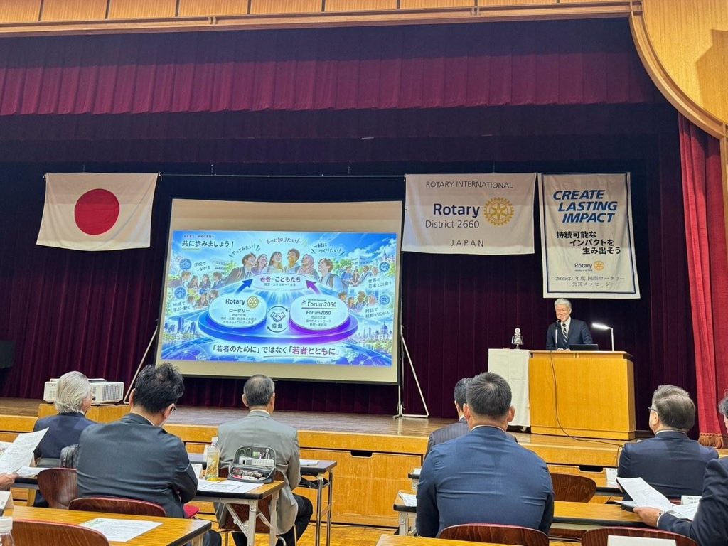 大阪北ロータリークラブで講演する戸田隆夫。スクリーンには「『若者のために』ではなく『若者とともに』」の文字